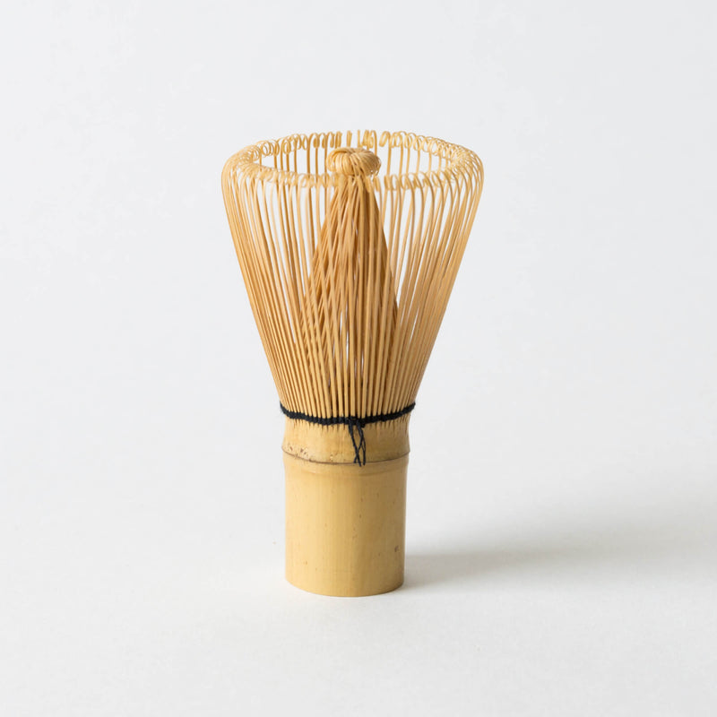 A Matcha Tea Whisk by Hangzhou Green Rock Co., Ltd., featuring finely spaced tines for perfect matcha whisking, stands upright against a plain white background.