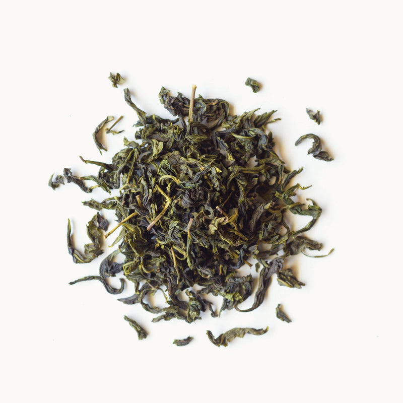 A small pile of loose-leaf Bergamot Oolong tea from Rishi Tea & Botanicals against a plain white background.