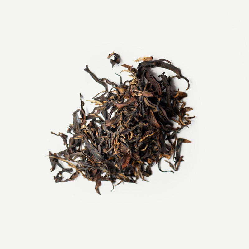 A pile of Dong Fang Hong loose leaf tea by Rishi Tea & Botanicals on a white background