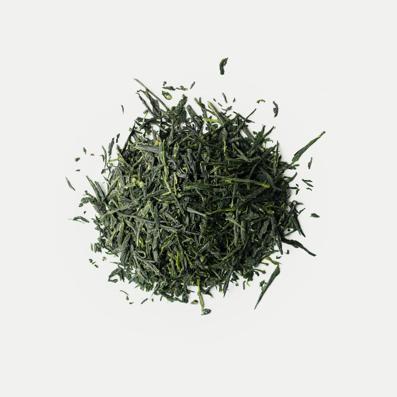 A pile of Uji Shuppin Gyokuro from Rishi Tea & Botanicals on a white surface.